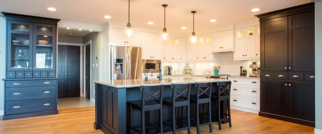 Modern kitchen with dark wood cabinets, white countertops, pendant lighting, and hardwood flooring.