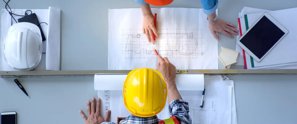 hidden oil tanks middletown colts neck nj home remodeling two contractors reviewing architectural blueprints on desk with safety gear