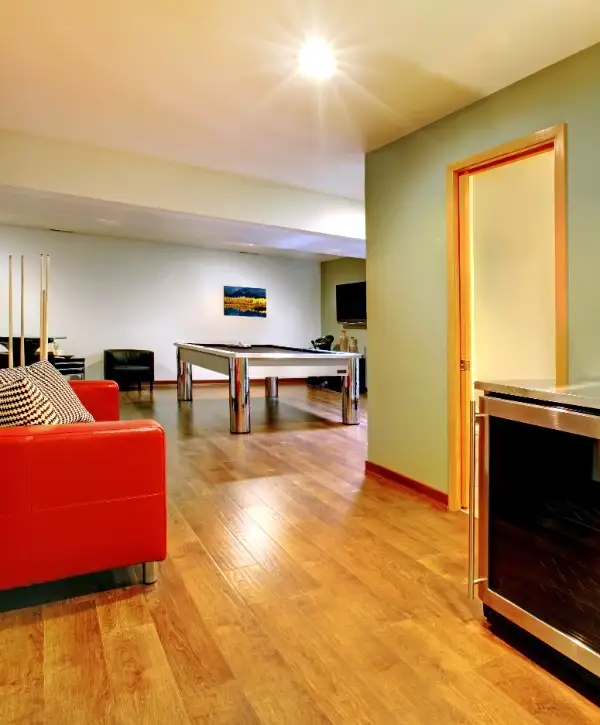 A basement featuring a pool table and a refrigerator, creating a casual and entertaining atmosphere