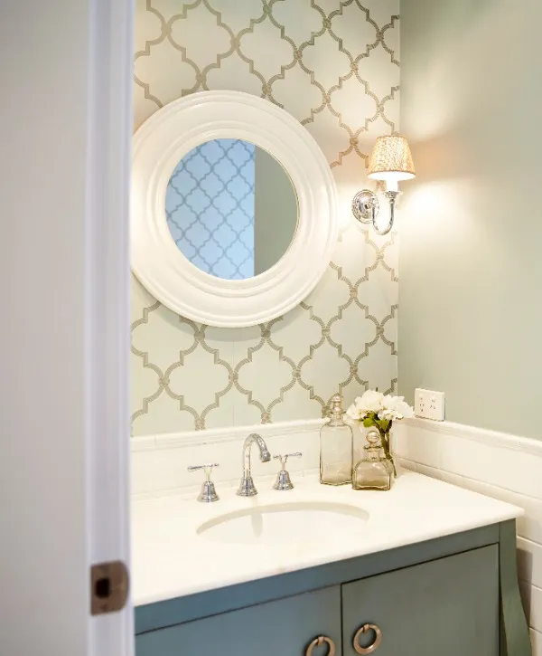 A bathroom featuring a round mirror above a modern sink with neutral colored walls and a clean, minimalist design