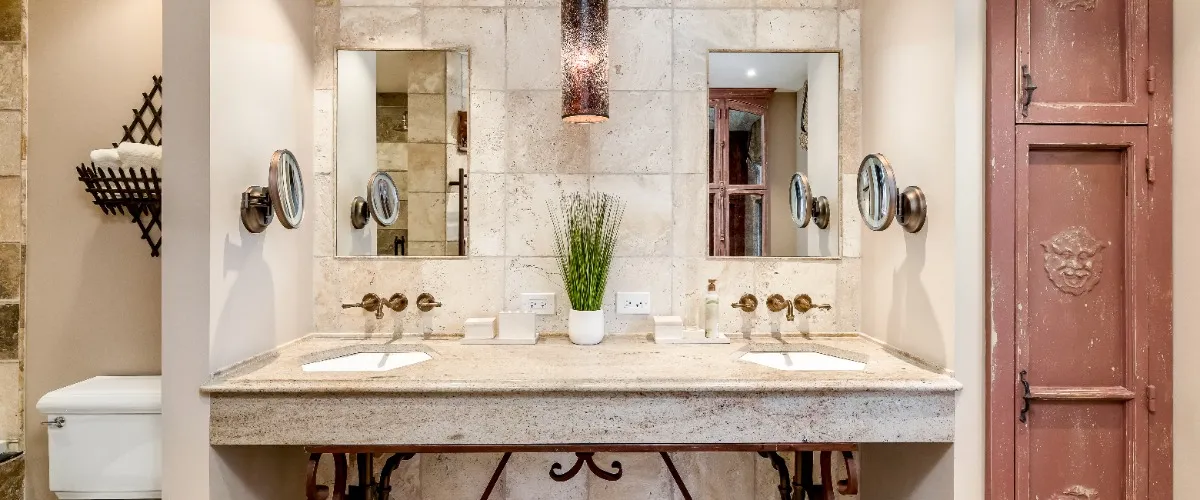 A clean bathroom with a sink and two mirrors, providing a spacious and well lit appearance