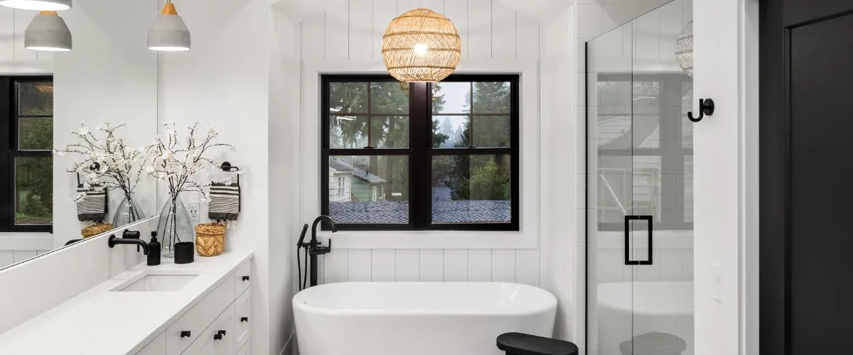 A modern bathroom featuring a stylish black and white color scheme with sleek fixtures and decor
