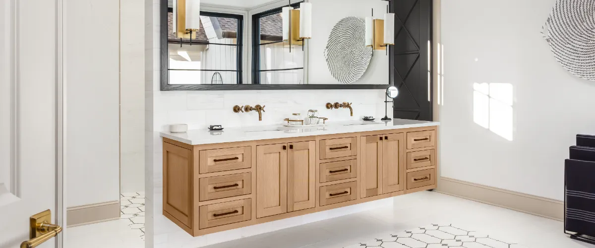 A modern bathroom featuring a wooden vanity with gold fixtures, large mirrors, and sleek decor, complemented by elegant lighting.