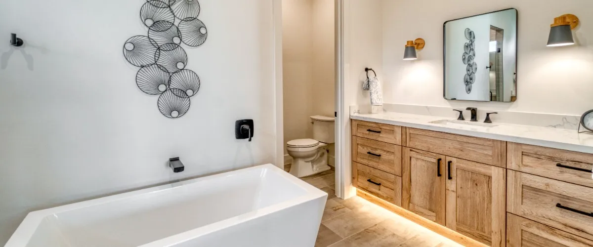 A modern bathroom showcasing a white tub and sink, surrounded by light colored walls and decorative accents