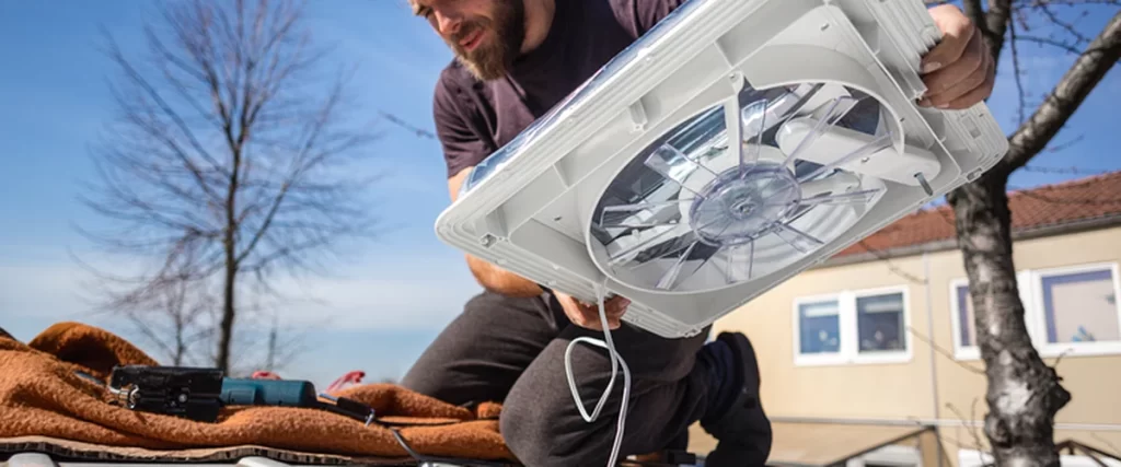 bathroom remodeling red bank nj a professional contractor installs a white commercial grade roof vent fan outdoors