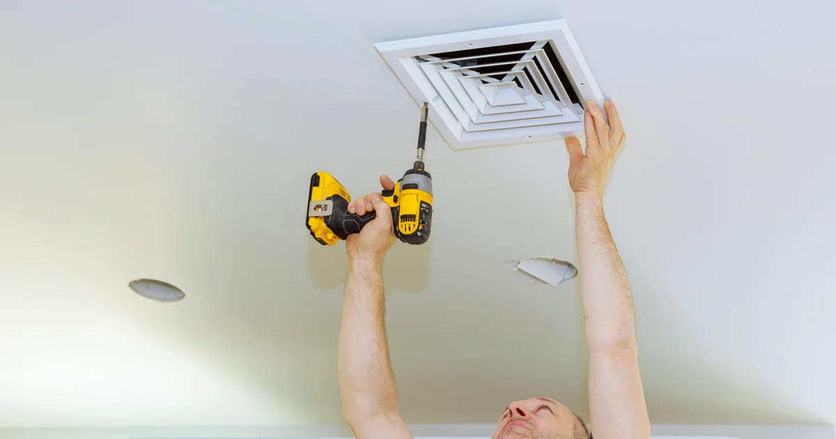 bathroom remodeling red bank nj professional contractor installing white ceiling vent with yellow power drill