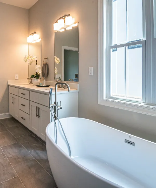 a modern bathroom with A large, white freestanding bathtub with a floor mounted faucet
