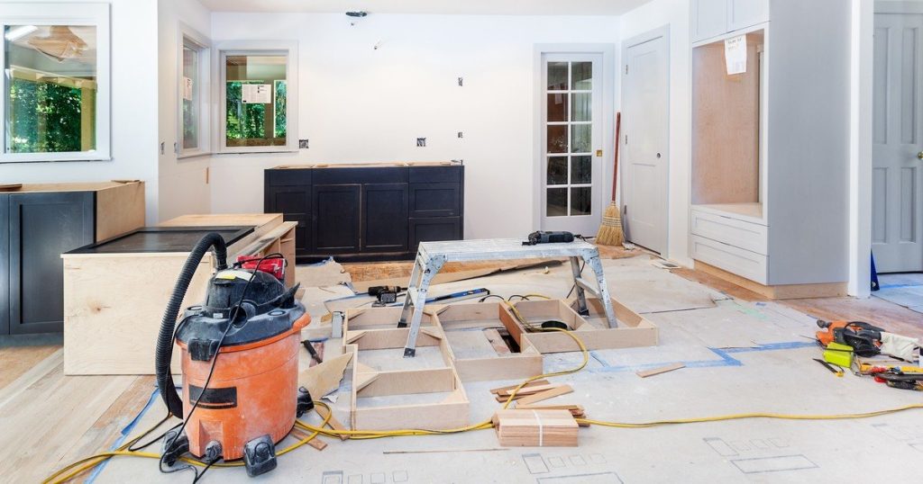 A work-in-progress shot of a kitchen renovation addressing Middletown, NJ kitchen layout issues with shop vacs, tools, and new cabinet frames visible.