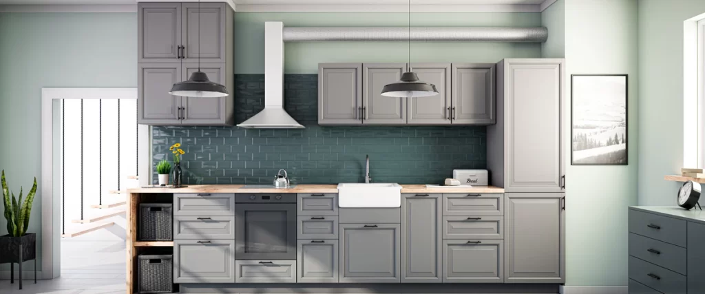 Modern grey shaker-style kitchen cabinet units installed against a dark green subway tile backsplash with a light wood countertop and white farmhouse sink.