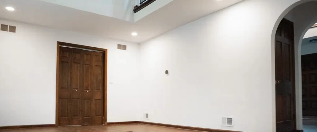 Open concept basement remodel with high ceilings, hardwood trim, and loft-style railing design
